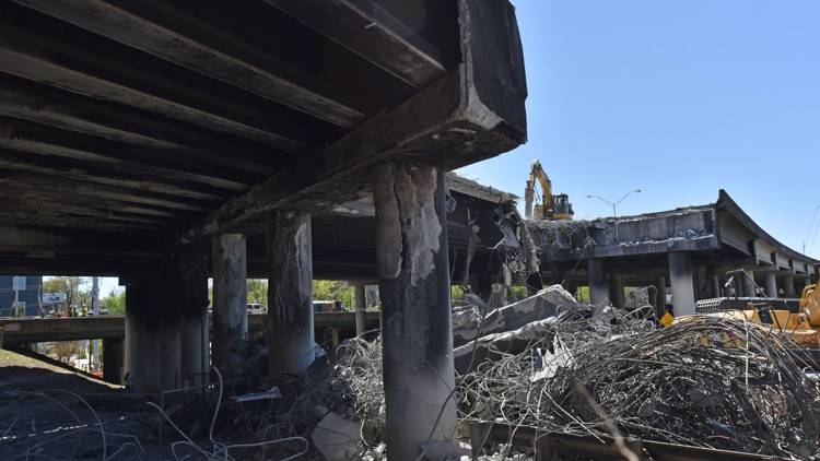 Crews demolish a damaged section of I-85 bridge